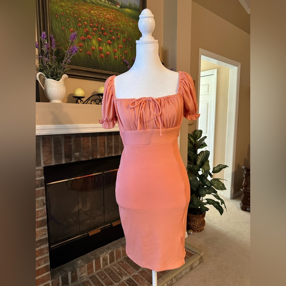 A coral colored backless mini dress with bow ties in the front & back.